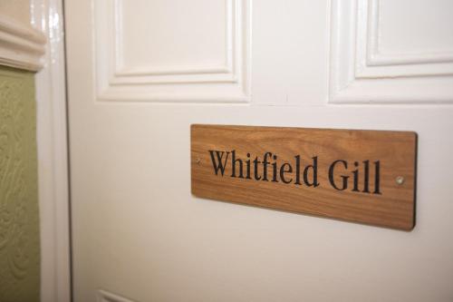 a sign on a white door with the word painted on it at Milton House Studio Apartments Askrigg in Askrigg