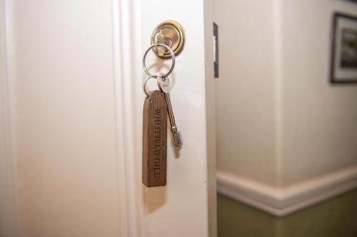 a key hanging from a door with a key chain at Milton House Studio Apartments Askrigg in Askrigg
