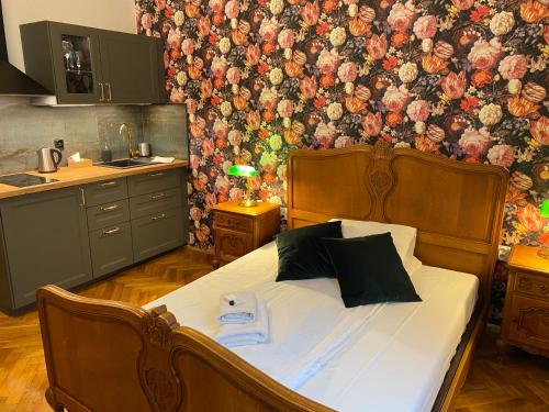 - une chambre avec un lit orné d'un mur fleuri dans l'établissement Aparthotel Maria, à Cracovie