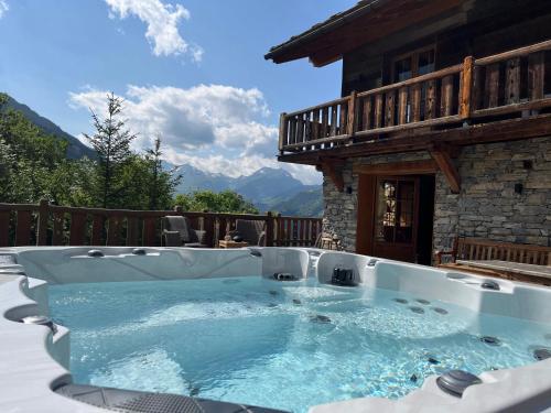 a hot tub on the patio of a house at Chalet Ruitor, chalet 500 m2 luxueux de caractère in Sainte-Foy-Tarentaise