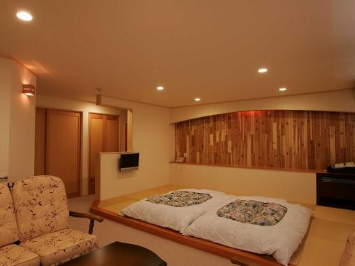 a bedroom with a bed and a couch and a chair at Nakaodaira in Takayama
