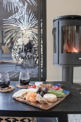 a tray of food on a table with two glasses of wine at Villa View in Halls Gap
