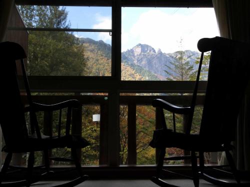 two chairs sitting in front of a window with a view at Nakaodaira in Takayama