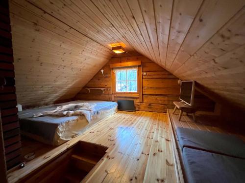een slaapkamer met een bed en een televisie op zolder bij Black Work Levi Autti in Kittilä