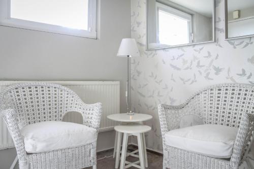 duas cadeiras de vime e uma mesa num quarto em Studio by the Beach em Gdansk