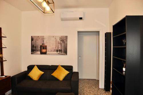 een woonkamer met een zwarte bank en gele kussens bij M.Aurelio (Nolo) Black & White in Milaan