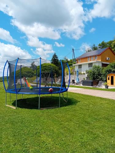 un trampoline bleu avec des balles dans l'herbe dans l'établissement Villa Four Stars ART-PE, à Trebnje