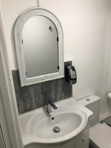 a bathroom with a white sink and a mirror at Budget room en-suite 8mins walk to Singleton Hospital, R3 in Sketty