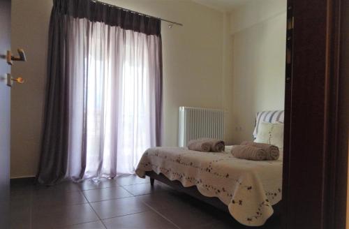 - une chambre avec un lit en face d'une fenêtre dans l'établissement Samaras Apartments in Kamena Vourla, à Kamena Vourla