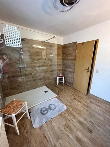 ein Bad mit einer Dusche, einem Tisch und einem Stuhl in der Unterkunft Ferienwohnungen Wotan in Thale