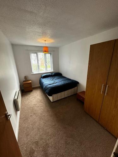 a small bedroom with a bed and a window at 2 Bedroom Apartment - 11 Parry Court in Nottingham