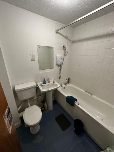 a bathroom with a toilet and a tub and a sink at 2 Bedroom Apartment - 11 Parry Court in Nottingham