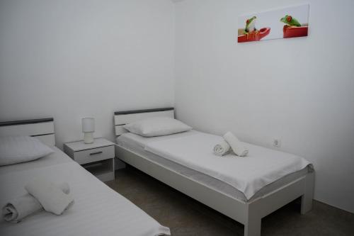two beds in a room with white walls at Villa Vinko in Trogir