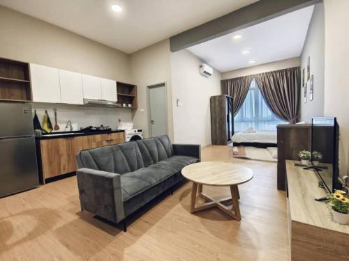 a living room with a couch and a table and a kitchen at Valley Suites by WyattHomes in Kuantan