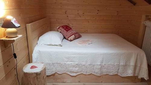 una piccola camera da letto con un letto in una camera in legno di B&B ABETE BIANCO ad Auronzo di Cadore