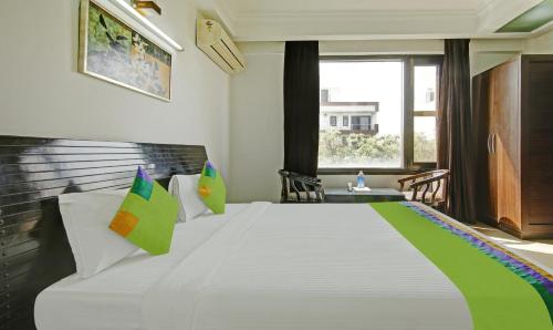 a bedroom with a large white bed with colorful pillows at Blue Moon Residency Hotel & Restaurant in Gurgaon
