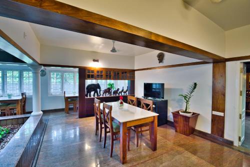 a kitchen and dining room with a table and chairs at Softouch Ayurveda Village Kerala in Kizhake Chālakudi