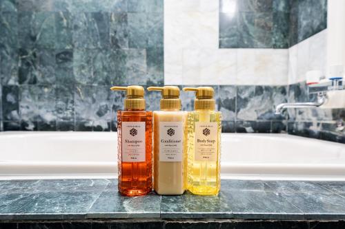 drie flessen essentiële oliën op een aanrecht in een badkamer bij SUA HOTEL Nishikasai in Tokyo