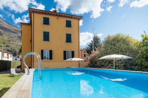 Villa con piscina frente a un edificio en Lucca Franco's Villa, en Diecimo