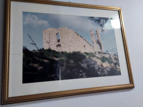a framed picture of a building on a wall at AurHouse in Castel di Iudica