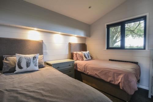 a small bedroom with two beds and a window at Oakwood 2 Pinewood Retreat in Lyme Regis