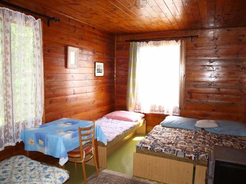 Habitación con 2 camas, mesa y ventana en Gemütliches Blockhaus am Moldaustausee, en Horní Planá