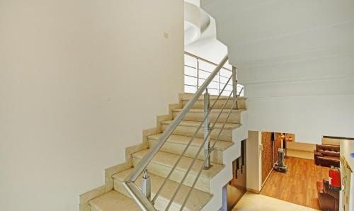 a staircase in a home with white walls and wooden floors at Blue Moon Residency Hotel & Restaurant in Gurgaon