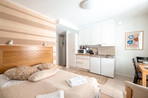 a bedroom with a large bed and a kitchen at 2ndhomes Compact Studio by the Esplanade Park in Helsinki