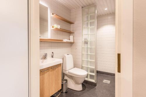 a small bathroom with a toilet and a sink at Hotelli Fennada in Vierumäki