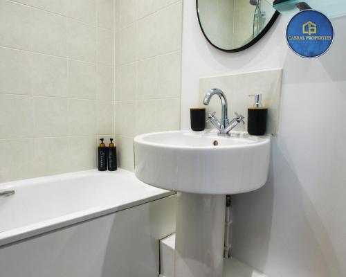 a white bathroom with a sink and a mirror at 2 Bedroom House By Cabral Properties Monthly special price in Reading