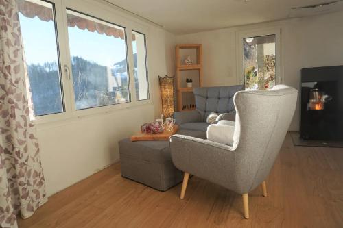 a living room with a chair and a couch at HERZLI-CHALET über dem Rheintal mit Schlossblick in Werdenberg