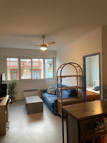 un salon avec un canapé bleu et une fenêtre dans l'établissement Appartement 2 pièces 37m2,350m de la plage, à Nice