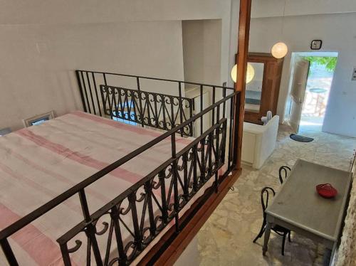a bedroom with a large bed and a table at Στούντιο σε πέτρινο σπίτι, κοντά σε παραλία in Kyparissia