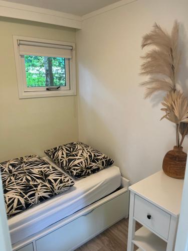 a small room with a bed and a window at Sfeervol vakantiehuisje in bosrijke omgeving in Vorden