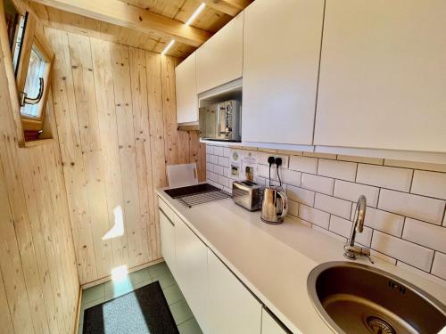 a kitchen with a sink and a counter top at Lushna 12 Lux at Lee Wick Farm Cottages & Glamping in Clacton-on-Sea