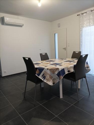 une table à manger avec des chaises et un tissu de table dans l'établissement Maison récente Océadune à Saint-Jean de Monts, à Saint-Jean-de-Monts