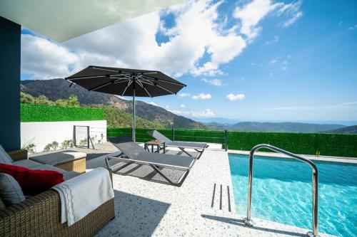 Villa Oxy Private Pools & Seaview & Heated Indoor Pool في غوجيك: فناء فيه مظله ومسبح