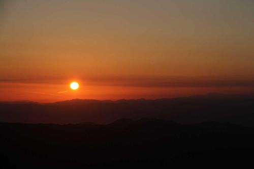 a sunset with the sun setting over the mountains at Nakaodaira in Takayama