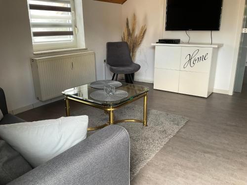a living room with a couch and a glass table at Apartment Auszeit in Bad Neustadt an der Saale