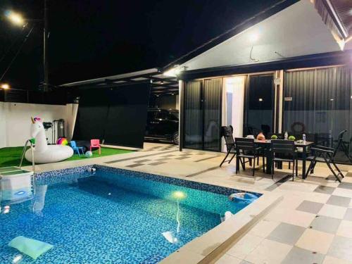 a house with a swimming pool and a dining table at Abbie's Private Pool Villa Bukit Mertajam Penang in Bukit Mertajam