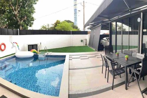 a swimming pool in a backyard with a table and chairs at Abbie's Private Pool Villa Bukit Mertajam Penang in Bukit Mertajam