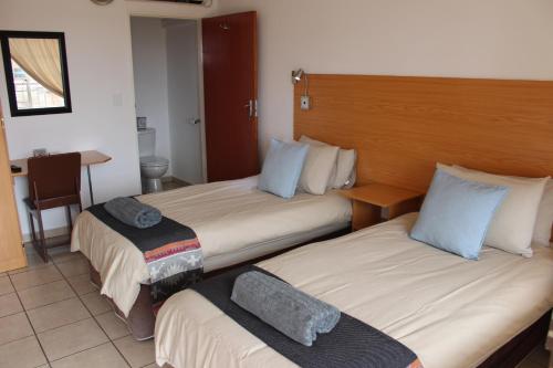 ein Hotelzimmer mit 2 Betten und einem Schreibtisch in der Unterkunft Mon Reve in Lephalale