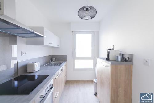 eine weiße Küche mit einem Waschbecken und einem Fenster in der Unterkunft Beautiful Appartement & Parking - Vieux-Port in Marseille