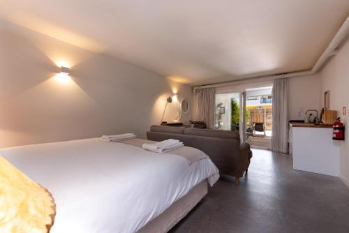 a bedroom with a large white bed and a couch at The 98 Place Carcavelos in Carcavelos
