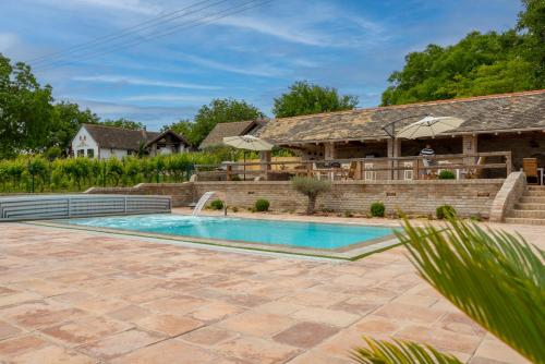una imagen de una piscina en un patio trasero con una casa en Provence Birtok en Decs