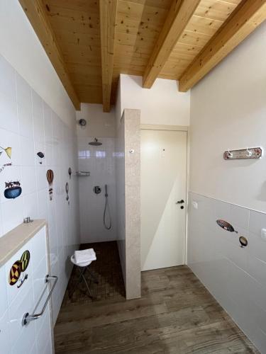 y baño con ducha, paredes blancas y techos de madera. en Agriturismo Corte Ambrosio, en Pozzolengo