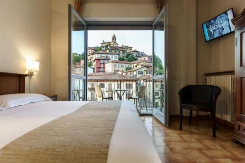 a hotel room with a bed and a large window at Hotel Il Grappolo D'Oro in Monforte dʼAlba