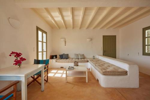 een woonkamer met een bank en een tafel bij Ochre Dream, Beach front & Sunset villa Naousa in Naousa