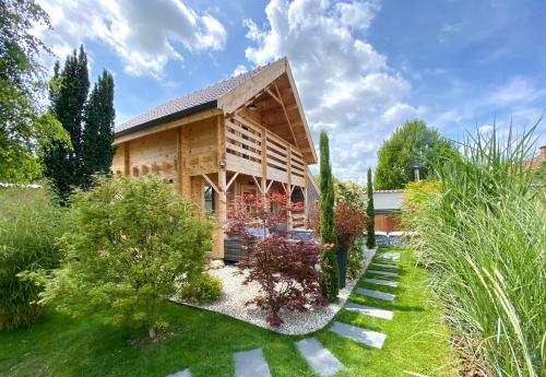 a wooden house with a garden in front of it at La Maison de Manolie in Courcelles-Sapicourt