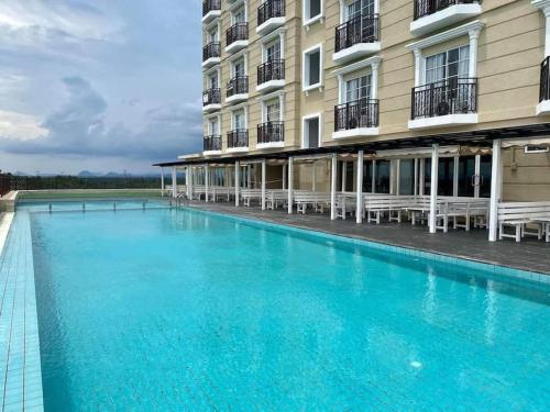 a large swimming pool in front of a building at Pool View at Sweet Home II-Champs Elysees, Kampar in Kampar